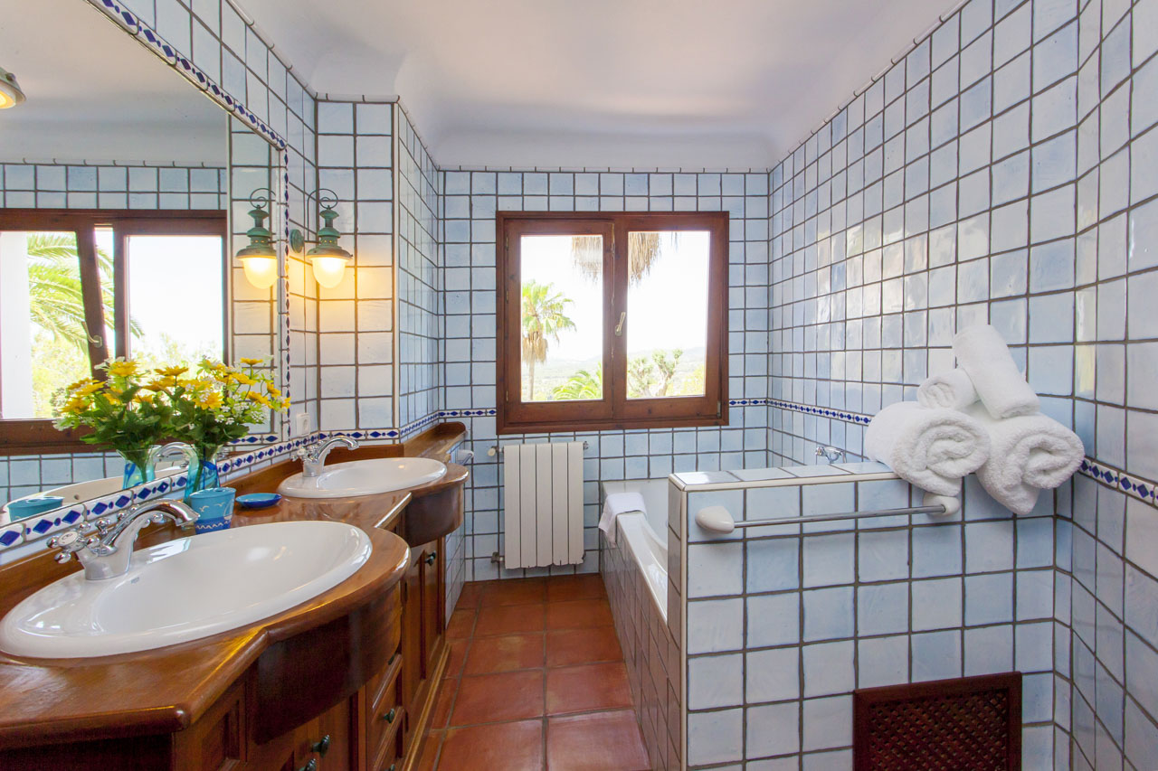 baño privado de habitacion azul con bañera y lavavo doble